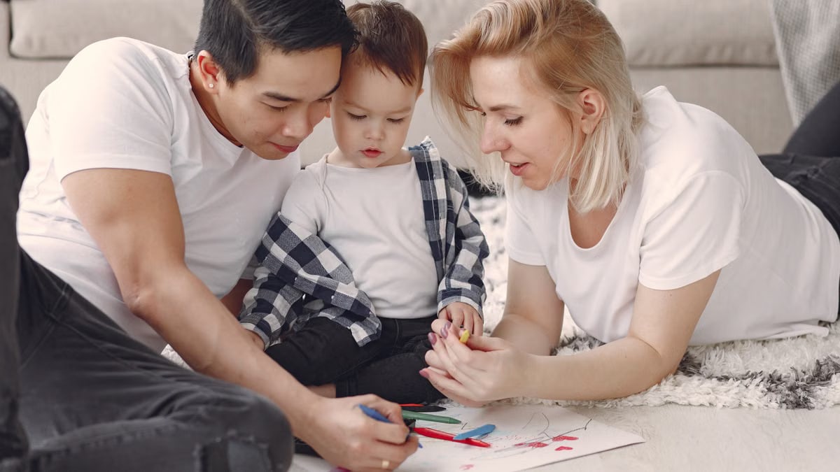 Loving family creating art together, fostering play and connection indoors.